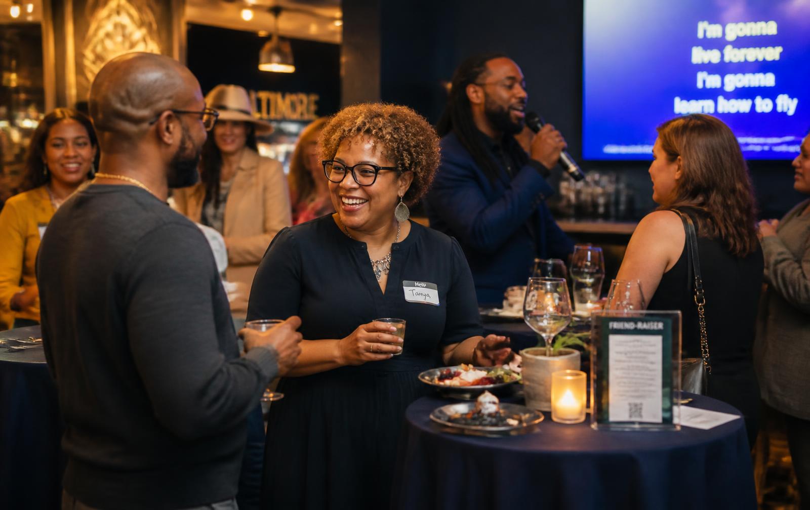 Aspirational scene of adults socializing at an evening community friend-raiser with drinks, food, and conversation